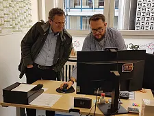 Zwei Personen im Büro schauen gemeinsam auf einen Bildschirm