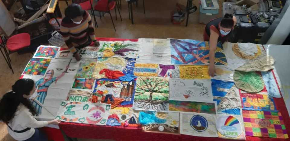 Frauen arbeiten an einem Quilt. Viele idividuell gestaltete Stoffst&uuml;cke werden zu einer Decke zusammengen&auml;ht.
