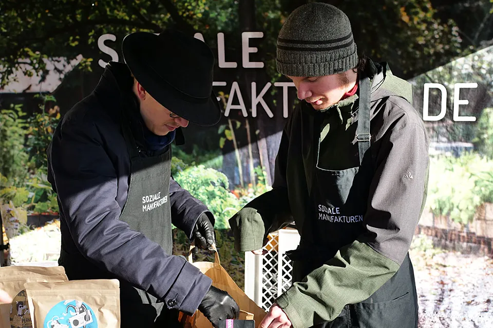 Zwei Personen packen waren in eine Papiert&uuml;te
