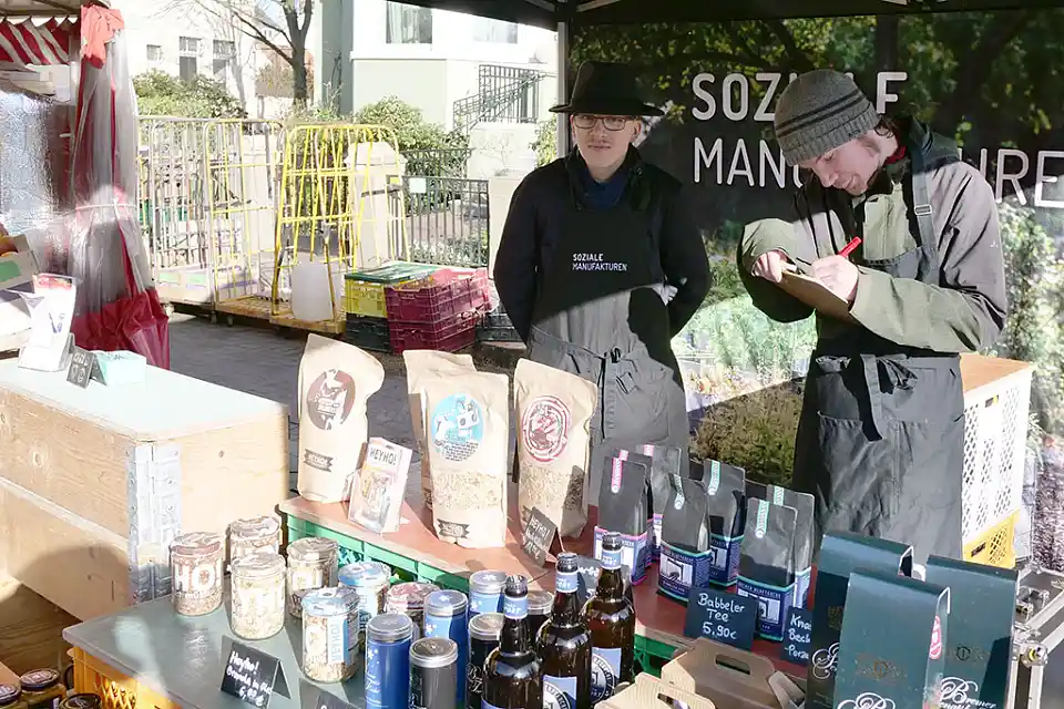 Zwei Personen hinter dem Markstand