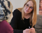 Berater*in in einem Gespräch mit einer weiblichen Person mit Migrationshintergrund. 
˜ Bildnachweis: eventfive GmbH, Indra Zilm