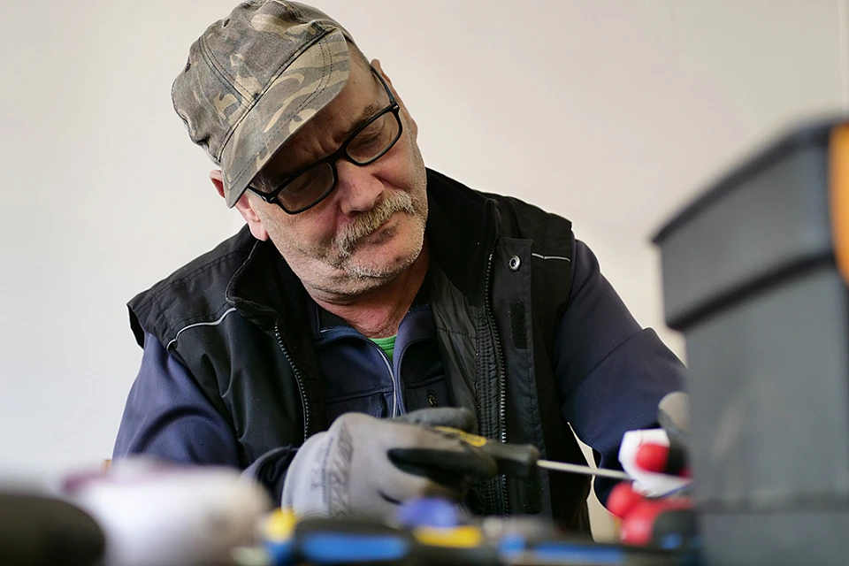 Person l&ouml;st Metall von einem Objekt