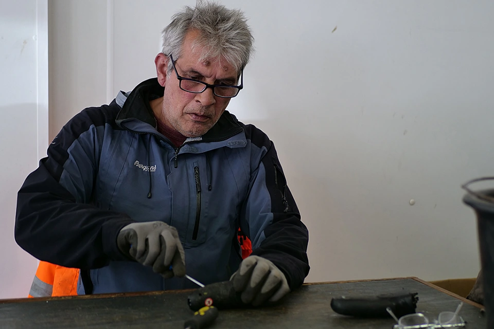 Person l&ouml;st etwas mit einem Schraubenzieher