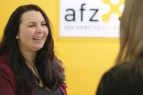 Zwei Frauen in einem Beratungsgespräch vor einer gelben Wand mit AFZ Schiftzug 
&tilde; Bildnachweis: eventfive GmbH, Indra Zilm