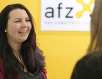 Zwei Frauen in einem Beratungsgespräch vor einer gelben Wand mit AFZ Schiftzug 
˜ Bildnachweis: eventfive GmbH, Indra Zilm