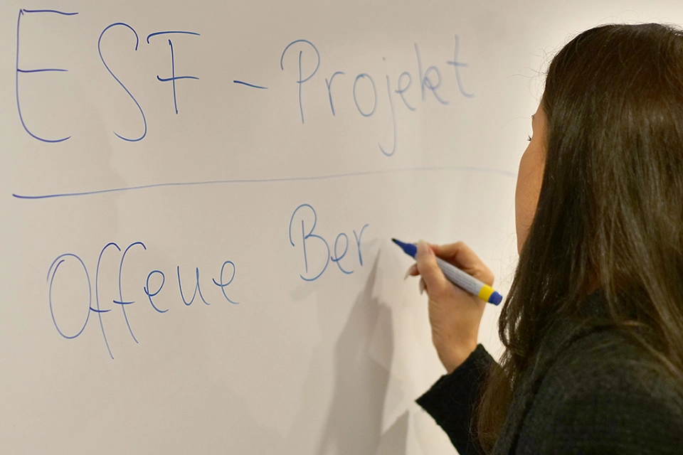 Eine Frau schreibt offene Bratung an ein Whiteboard