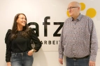 Zwei Personen aus dem AFZ Team stehen vorm einem AFZ Plakat und schauen sich an. 
&tilde; Bildnachweis: eventfive GmbH, Indra Zilm
