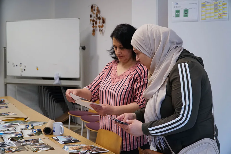 Zwei Teilnehmende w&auml;hlen gemeinsam Bilder aus