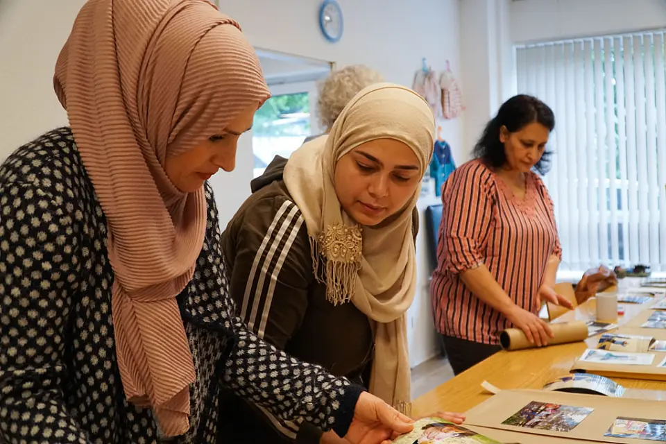 Zwei Frauen schauen auf Blatt mit Bildern