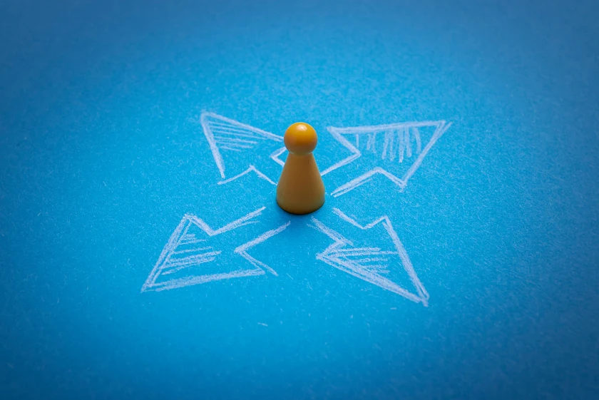 Gelbe Spielfigur mit Kreidepfeilen in alle Himmerlsrichtungen